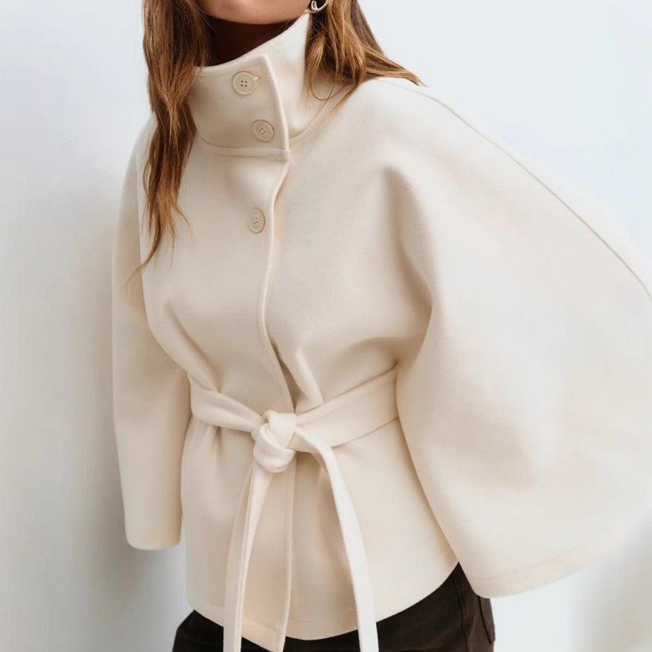 Beige coat with a belt worn by a person on a white background